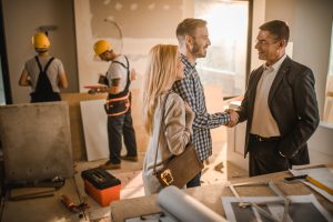 happy couple having an agreement with building contractor