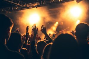 silhouettes of concert crowd in front of bright stage lights