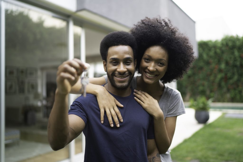 young happy couple holding the key of their new house